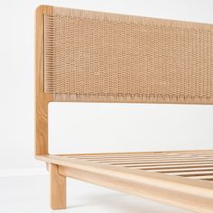 a wooden bed frame with wicker headboard and slatted backrests