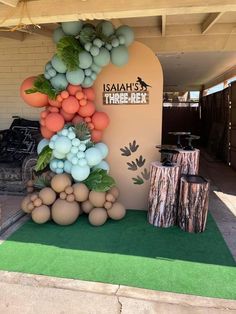 an outdoor display with balloons and greenery in the shape of a tree is shown