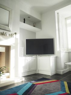 a flat screen tv sitting on top of a white cabinet