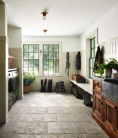 a laundry room filled with lots of different types of clothes hanging on the walls and windows