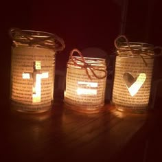 three mason jars with lit candles in them on top of a wooden table next to each other