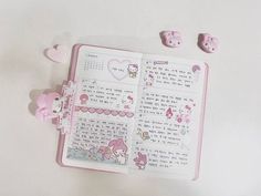 an open hello kitty book with pink decorations on the pages and some hearts around it