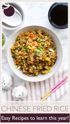 chinese fried rice in a white bowl with chopsticks and sauce on the side