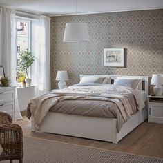 a bedroom with a bed, nightstands and two lamps on either side of the bed