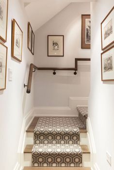 the stairs are lined with pictures and framed photographs on the wall above them, along with a bench