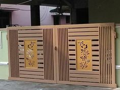 two wooden doors with designs on them in front of a wall and door to another building