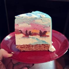 a piece of cake on a red plate with someone holding it up to the camera