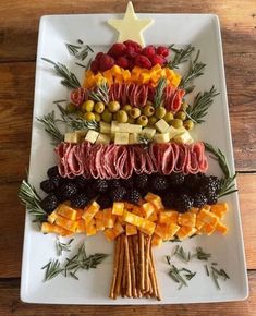 a christmas tree made out of fruits and veggies on a white platter