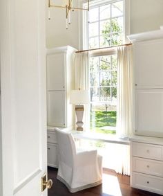 an open door leading to a room with white furniture