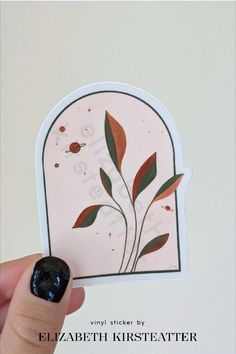 a person holding up a sticker with leaves on it