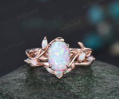 an opal ring is shown on top of a rock