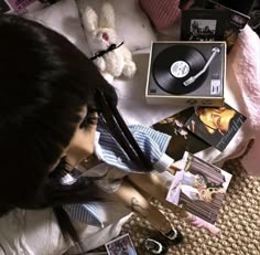 a doll is laying on the floor next to an old record player and other items