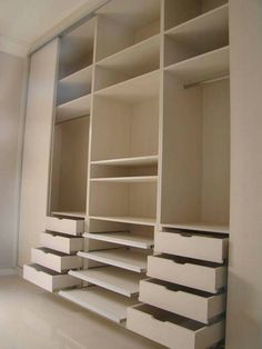 an empty white closet with drawers and shelves