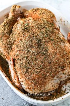 a close up of a chicken in a pan with seasoning on the top and sides