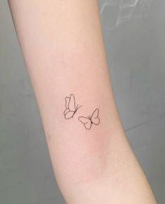 two butterflies tattoo on the right arm and left arm, with one small butterfly in the middle