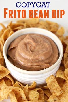 a white bowl filled with brown dip surrounded by tortilla chips