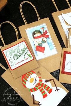 four bags with christmas cards on them sitting on a table