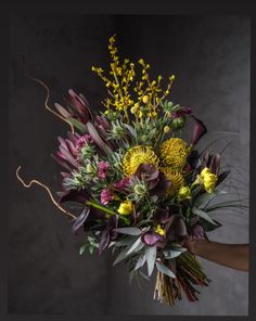 a woman holding a bouquet of flowers in her hands