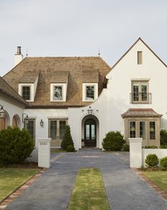 a large white house with brown shingles on the roof