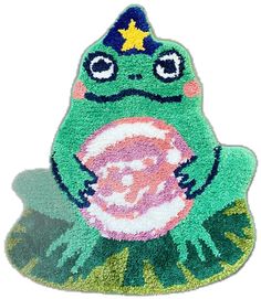 a green frog rug with a star on its head