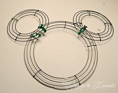 a mickey mouse head made out of wire and some green beads on top of it