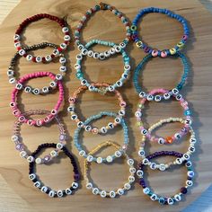 a bunch of bracelets that are sitting on a wooden table with eyeballs all over them