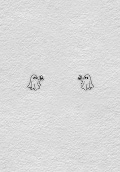 two little ghost stickers on the side of a white paper sheet with black ink