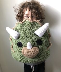 a woman is wearing a crocheted mask with horns on it's head