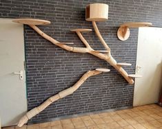 a tree made out of branches and wooden spoons hanging from the side of a brick wall