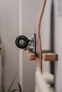 a skateboard mounted to the side of a wall with a wooden board attached to it