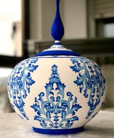 a blue and white vase sitting on top of a table