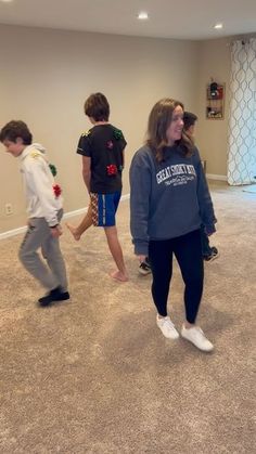 three young children are playing in an empty room