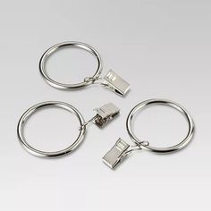 three metal key chains on a white background with clippings for each one to attach them