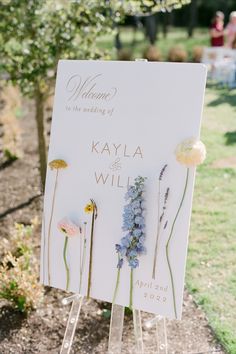 a sign with flowers on it sitting in the grass