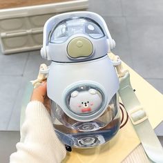 a person is holding up an electric device with a cat face on the front and side