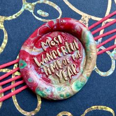 a red and gold brooch with writing on it that says, most wonderful time of the year