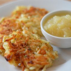 some food is on a white plate with a small bowl of gravy next to it