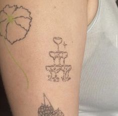 a woman's arm with tattoos on it, including a flower and a vase