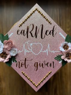 a pink graduation cap decorated with flowers and the words carried by mr and mrs not given