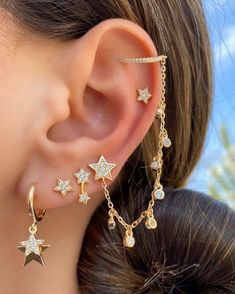 a close up of a person's ear with three stars on it and dangling from the side