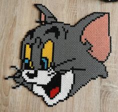 a close up of a piece of art made out of perler beads with an image of a cat on it