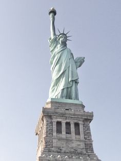 the statue of liberty is shown against a blue sky