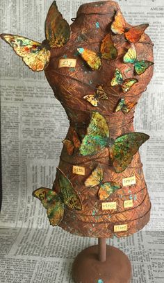 the sculpture is made out of paper and has many different butterflies on it's back