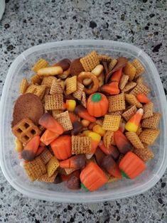 a plastic container filled with halloween snack mix