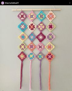 a crocheted wall hanging with two tassels