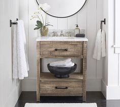 a bathroom with a sink, mirror and towel rack on the wall next to it