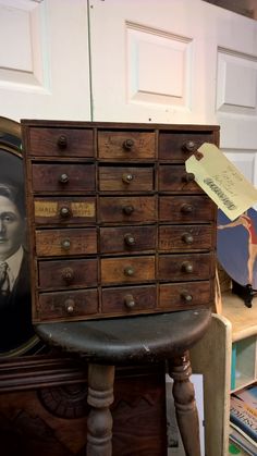 an old dresser with many drawers and pictures on it