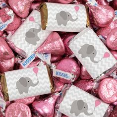 pink herse kisses with an elephant sticker on them are surrounded by hearts and candy