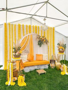 an outdoor tent decorated with yellow and white decor