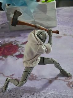 an action figure is posed on a bed with a hammer in it's hand